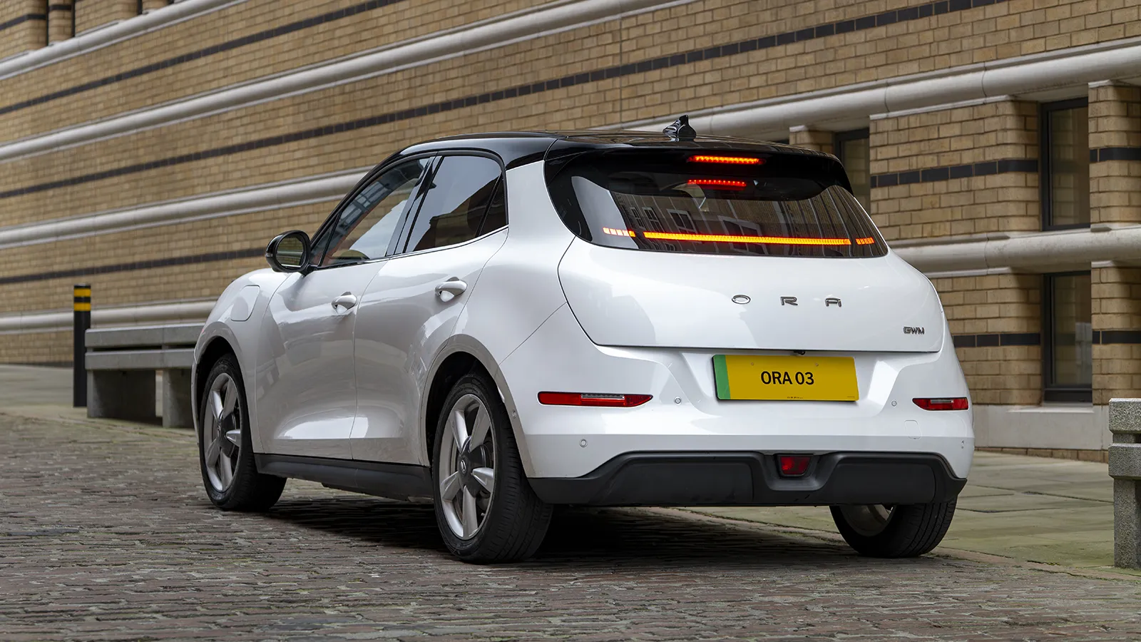 ORA 03 Moonlight White rear parked in the city